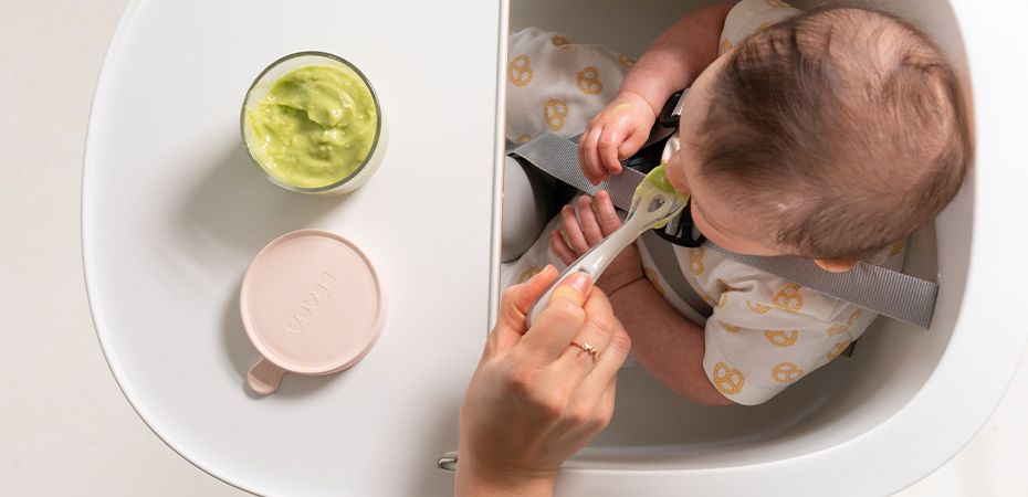 starting solids around the world baby being spoon fed green puree